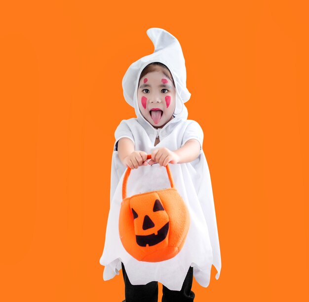 Feliz niño asiático hallooween en traje fantasma en naranja con trazado de recorte