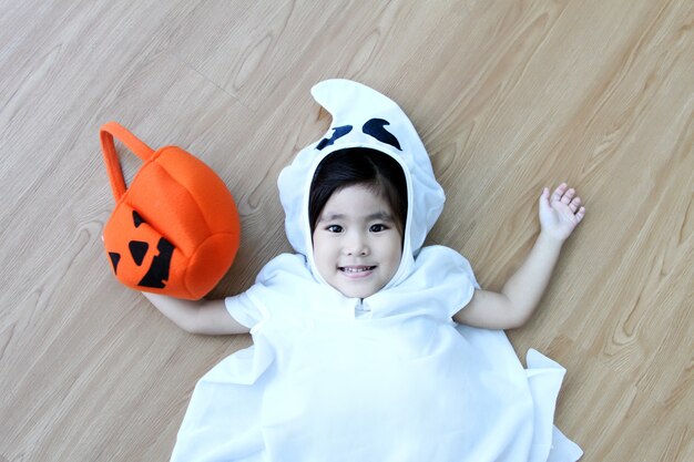 Feliz niño asiático hallooween en traje fantasma en rojo