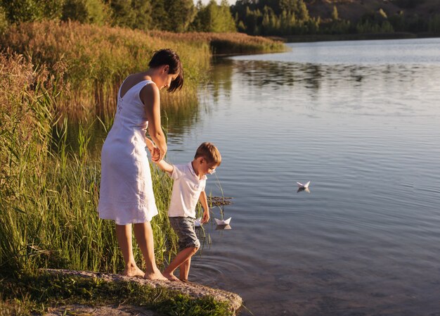 Feliz niño y madre cerca del lago