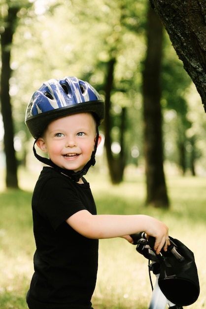 Feliz niño montando una bicicleta en el parque