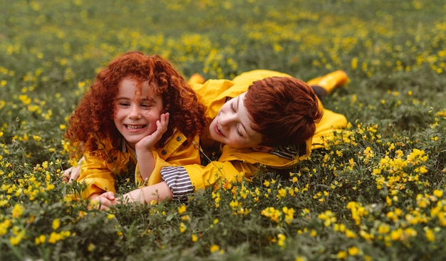 Feliz niño y niña pelirroja en impermeables