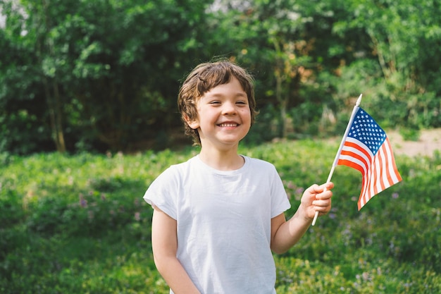 Feliz niño patriótico sosteniendo la bandera estadounidense EE.UU. celebra el 4 de julio Feliz día de la independencia