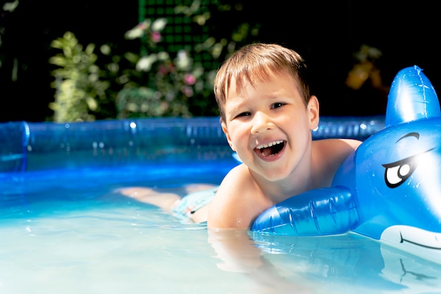 Feliz niño riendo divirtiéndose en una piscina