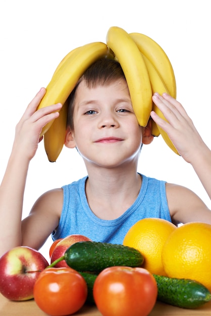 Foto feliz niño sano con plátanos y frutas aislados