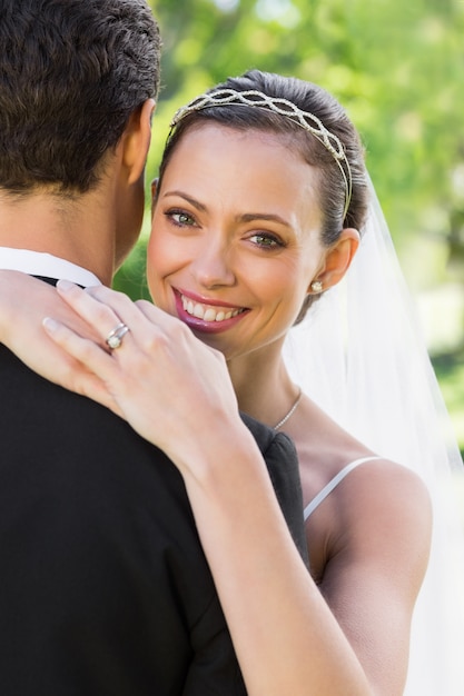 Feliz novia abrazando novio en el jardín