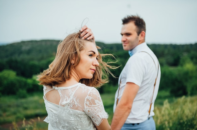 Feliz novia y el novio caminando sobre la hierba verde