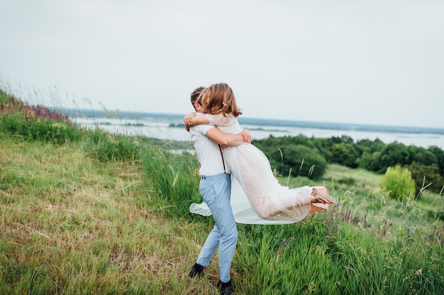 Feliz novia y el novio caminando sobre la hierba verde