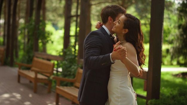 Feliz novia y el novio celebrando la boda bajo el arco Pareja teniendo el primer baile