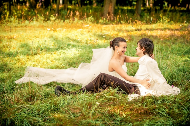 feliz novia y el novio en un paseo en el hermoso bosque