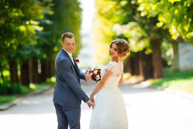 Feliz novia y el novio en su boda. Recién casados en el parque.