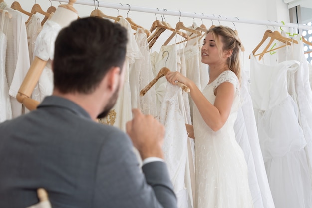 Foto feliz novia y el novio en vestido de novia se preparan para casarse en la ceremonia de la boda. amor romántico de pareja de hombre y mujer.