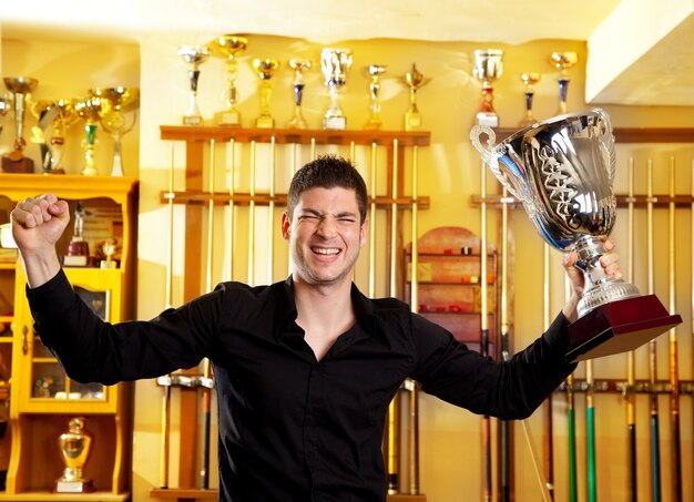 Foto feliz orgulloso hombre ganador con gran trofeo copa de plata