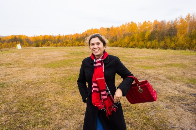 Feliz otoño niña. Mujer despreocupada alegre del otoño en tiempo nublado del parque.