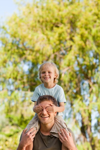 Feliz padre dando hijo a cuestas