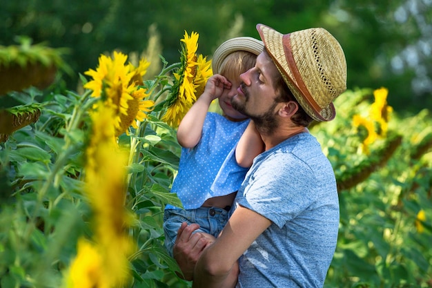 Feliz padre e hija se abrazan en el campo de los girasoles
