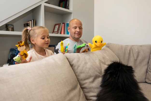 Feliz padre e hija jugando con títeres