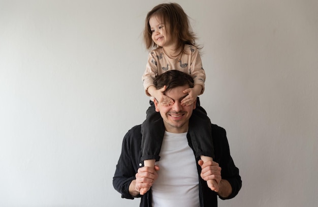 Feliz padre e hija linda jugando juntos escogen un abucheo escondiendo los ojos a cada uno con las manos