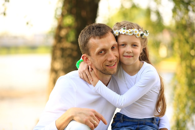 feliz padre e hija pequeña abrazándose en el parque