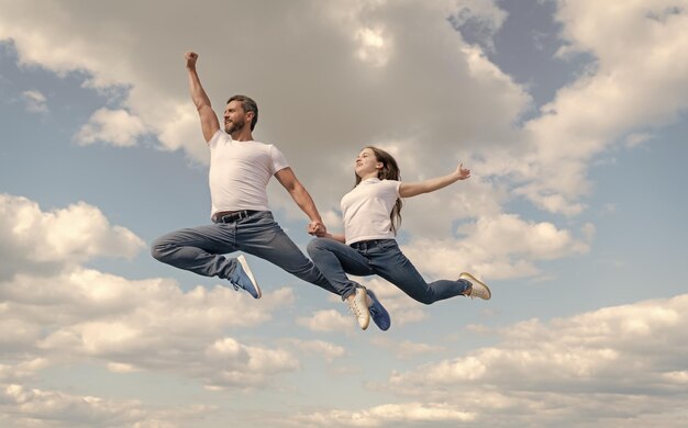 Feliz padre e hija saltan en el cielo día de la familia