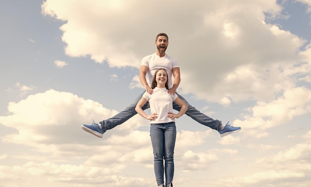 Foto feliz padre e hija saltan en el cielo divirtiéndose