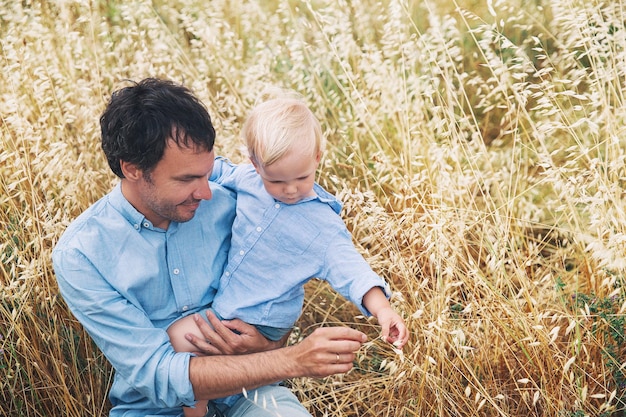 Feliz padre e hijo Antecedentes familiares Papá y su pequeño y lindo niño jugando y abrazándose en el campo de trigo con montones de heno en el día de verano en la naturaleza al aire libre Concepto de confianza confianza amor