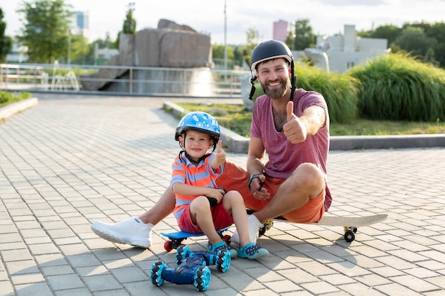 Feliz padre e hijo con cascos juegan en el parque con un coche robot controlado por un guante