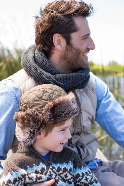 Feliz padre e hijo casuales en un lago