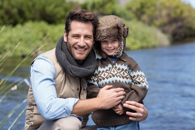 Foto feliz padre e hijo casuales en un lago
