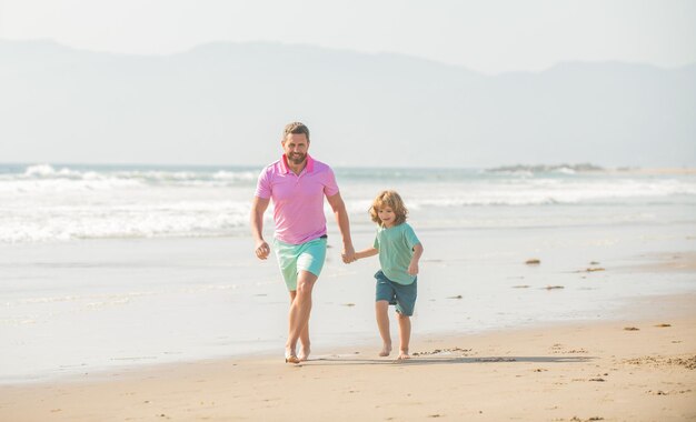 Feliz padre e hijo corren en la actividad de la playa de verano