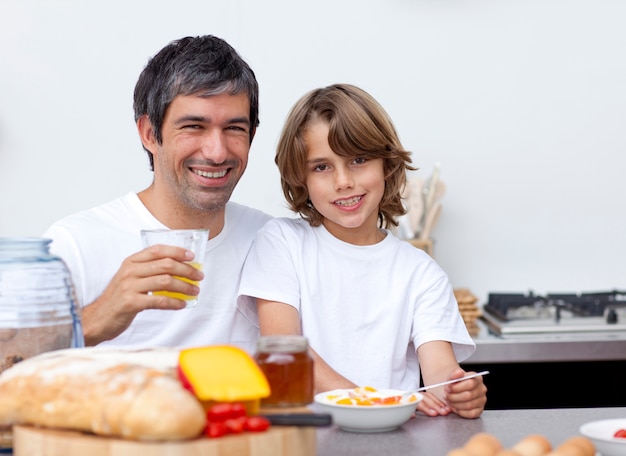 Foto feliz padre e hijo desayunando juntos