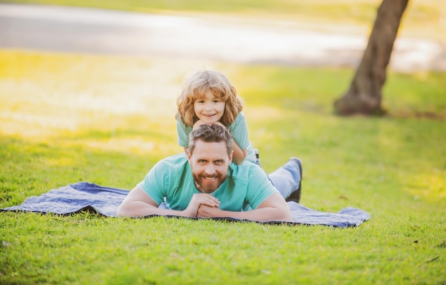 Feliz padre e hijo disfrutando del verano de vacaciones en un parque soleado