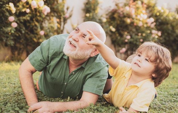 Feliz padre e hijo en el prado en verano niño lindo niño abrazando a su abuelo abuelo con hijo