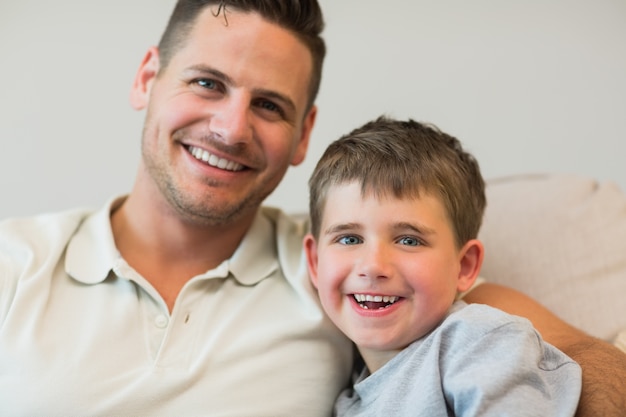 Foto feliz padre e hijo en el sofá