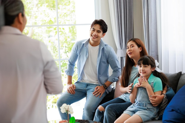 Feliz padre de familia, madre e hija, escuchen atentamente a la agencia de ventas de ancianos presente el detalle de la casa en la sala de estar