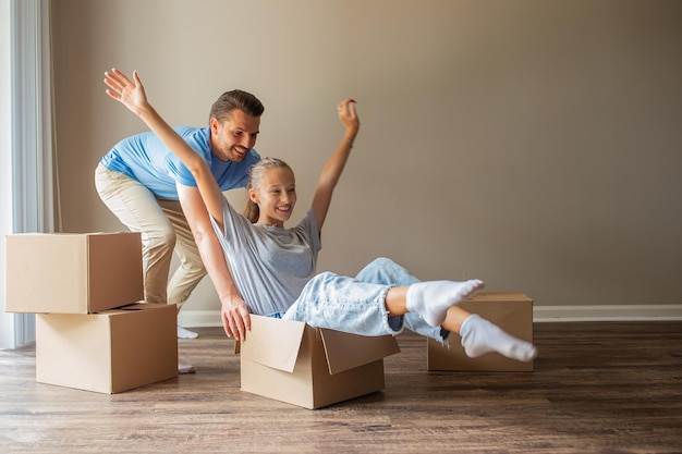 Feliz padre con hija diviértete en su nuevo hogar Familia disfruta su día de mudanza