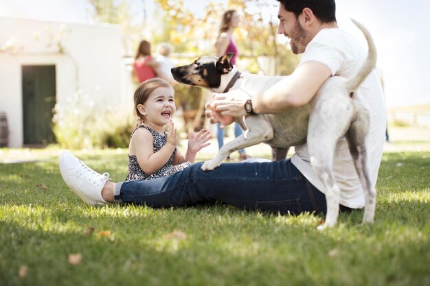 Feliz padre, hija y perro en el jardín