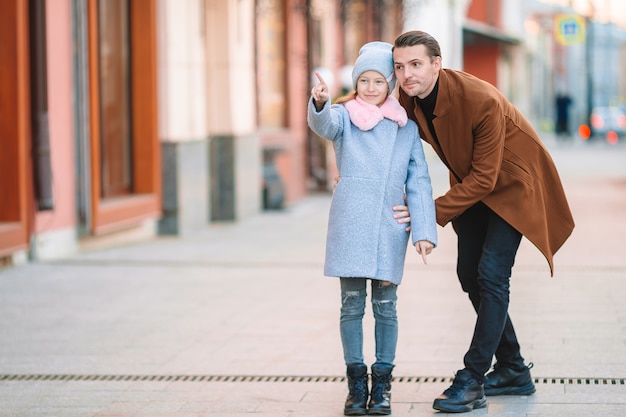 Feliz padre y niña adorable en la ciudad al aire libre