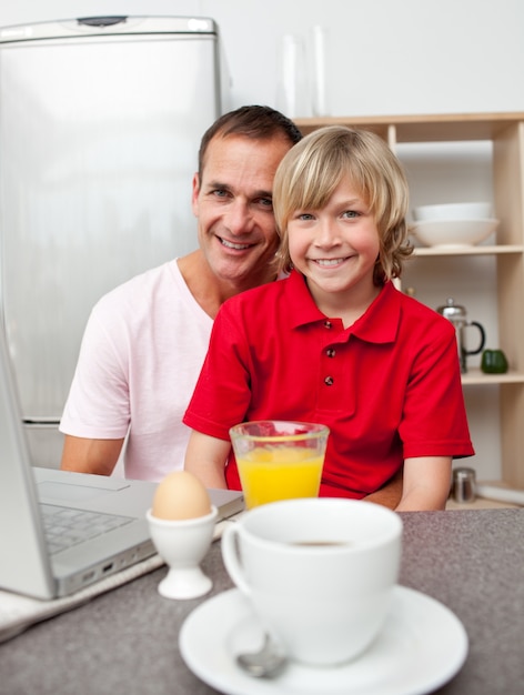 Feliz padre y su hijo desayunando