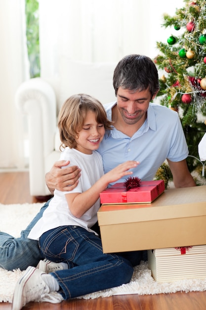 Feliz padre y su hijo con regalos de Navidad