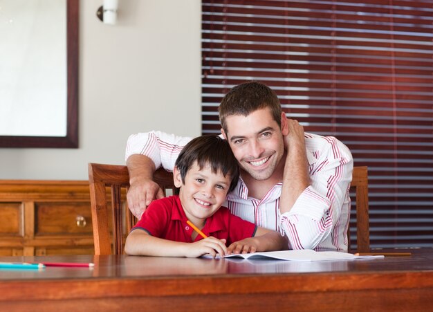 Feliz padre con su hijo sentado en una mesa