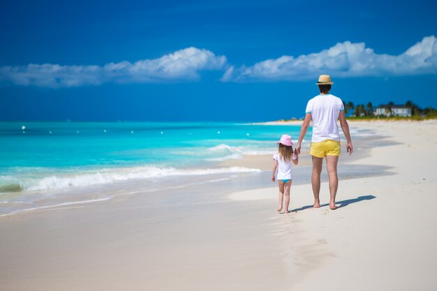 Feliz padre y su pequeña hija linda en la playa