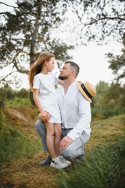 Feliz pai e filha brincando enquanto caminhava em um lindo parque de verão Pai de fim de semana ideal com sua filha pequena