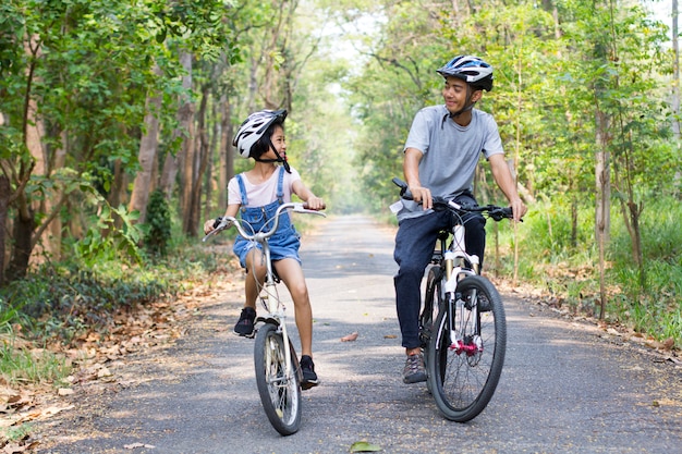 Feliz pai e filha de bicicleta no parque