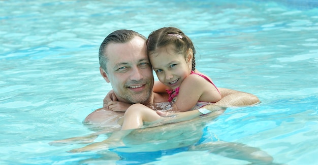 Feliz pai e filha relaxando na piscina