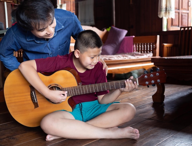 Feliz pai e filho tocando violão juntos pai ensinando filho a tocar violão em casa