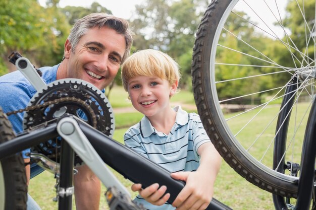 Feliz pai e seu filho corrigindo uma bicicleta