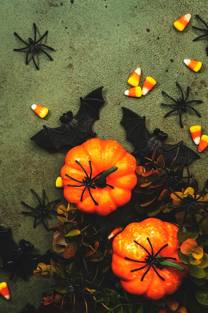 Feliz pântano de Halloween fundo verde com abóboras morcegos aranhas milho doce com espaço de cópia