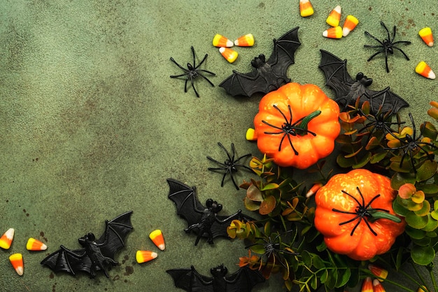 Feliz pântano de Halloween fundo verde com abóboras morcegos aranhas milho doce com espaço de cópia