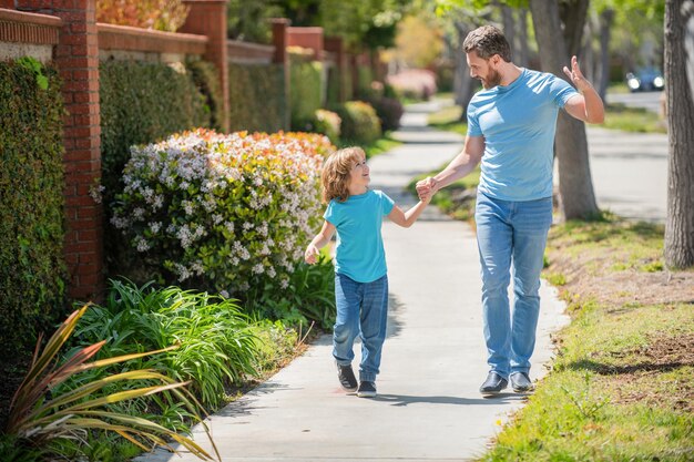 Feliz papá con niño caminan juntos en el parque de verano