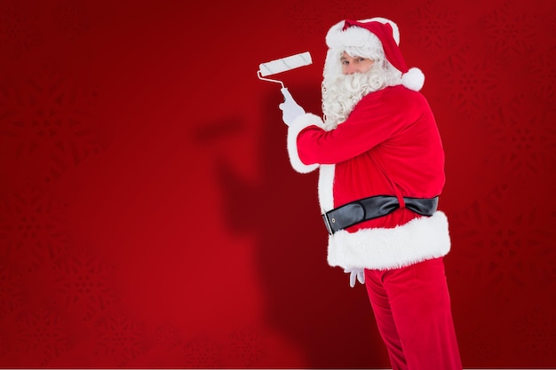 Feliz papai noel pintando contra o fundo vermelho do floco de neve